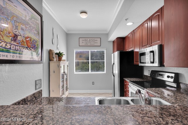 kitchen featuring ornamental molding, light tile patterned floors, stainless steel appliances, and sink