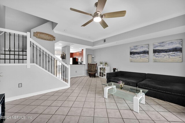 tiled living room with ceiling fan and crown molding