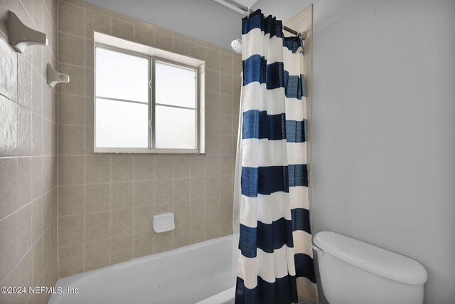 bathroom featuring shower / bath combo and toilet