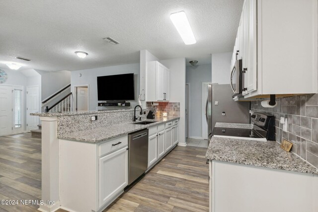 kitchen featuring light hardwood / wood-style flooring, white cabinetry, appliances with stainless steel finishes, and sink