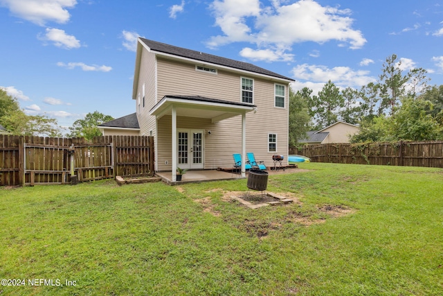 back of house with a lawn, a patio, and french doors