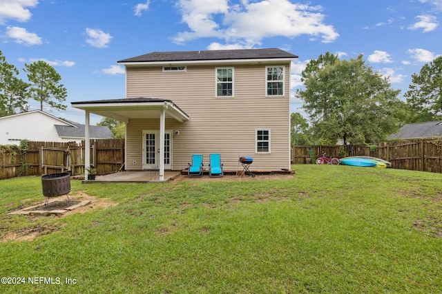 back of property with a lawn and a patio