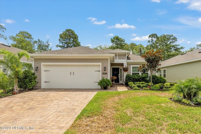 view of front of property with a front yard and a garage