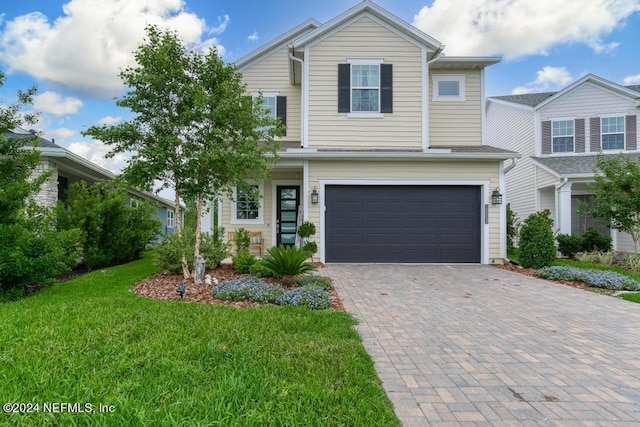 view of front of property with a front yard and a garage