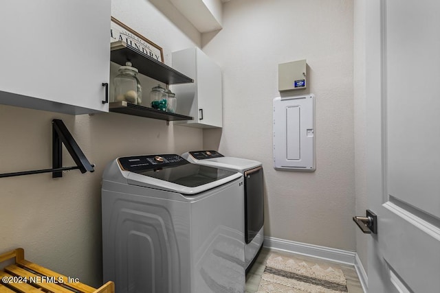 laundry area featuring washer and dryer, cabinets, and electric panel