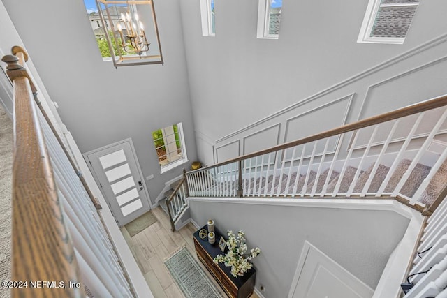 stairway featuring a high ceiling and a notable chandelier