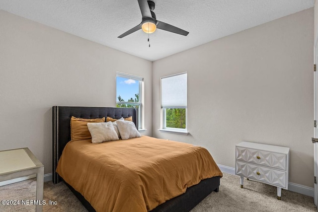 bedroom featuring ceiling fan, a textured ceiling, and carpet floors