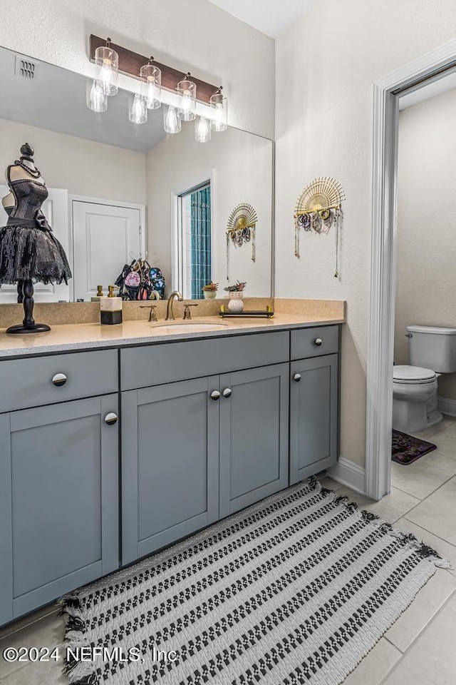 bathroom featuring vanity, toilet, and tile patterned flooring