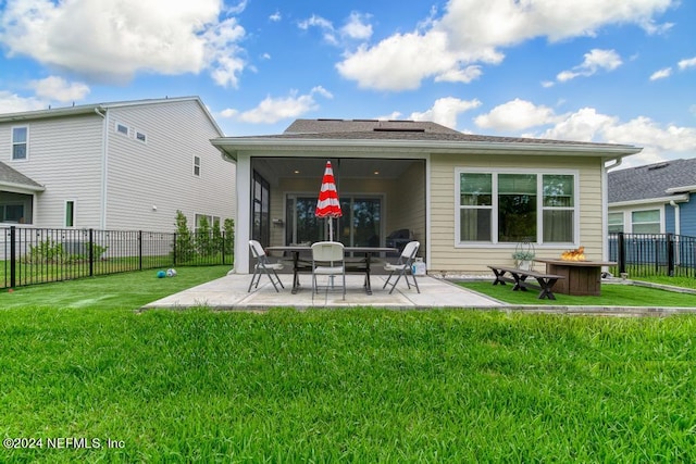 back of property with a yard and a patio