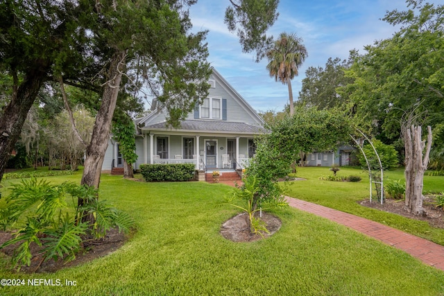 view of front of property with a porch, a front lawn, and a shingled roof