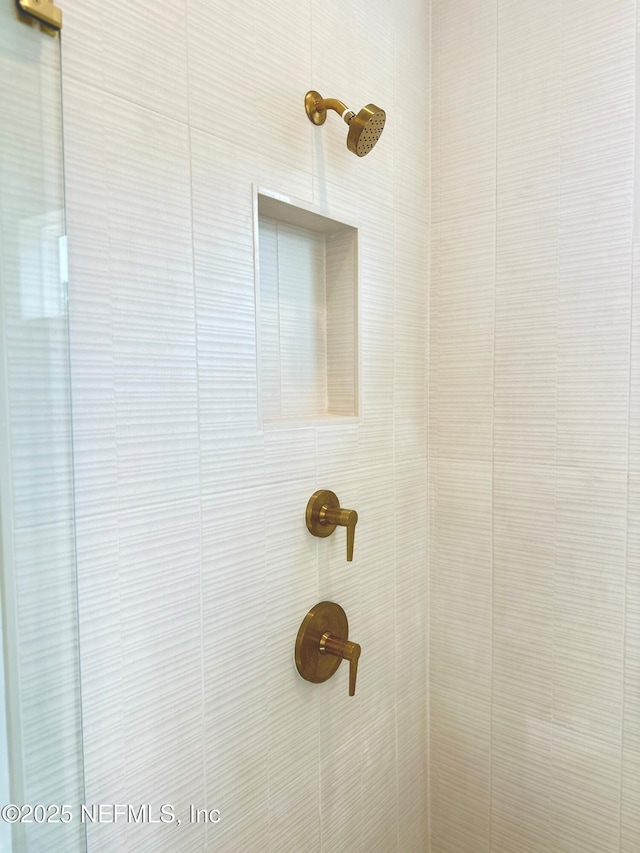 interior details featuring tiled shower