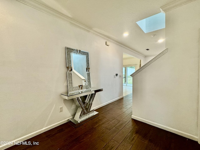 hallway featuring crown molding, dark hardwood / wood-style flooring, and a skylight