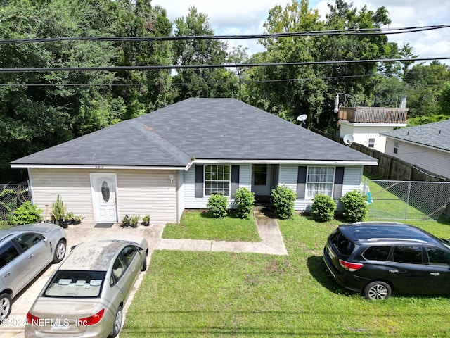 7071 Luke St, Jacksonville, FL 32210 - ranch-style house with a shingled roof, fence, and a front lawn