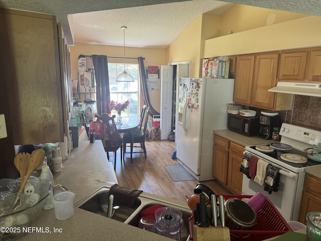 kitchen with decorative backsplash, hanging light fixtures, white appliances, a textured ceiling, and light wood-type flooring