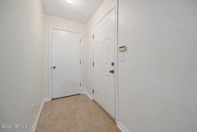 entryway featuring a textured ceiling and light tile patterned floors