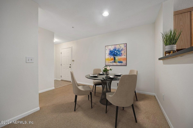 dining space featuring light carpet