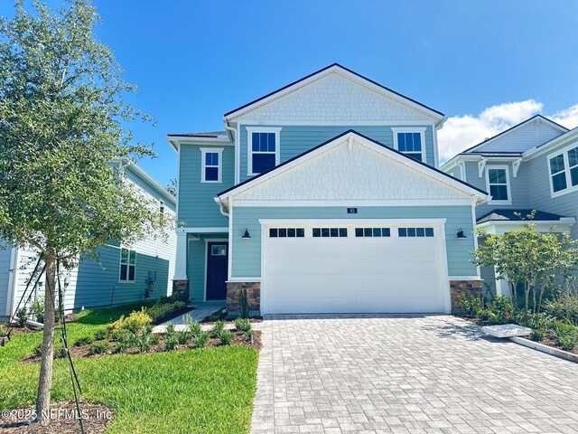 63 Oakmoss Dr, Saint Johns, FL 32259 - craftsman-style home with a garage, driveway, and stone siding