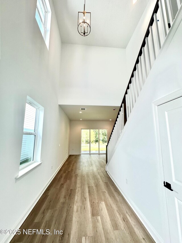 63 Oakmoss Dr, Saint Johns, FL 32259 - foyer entrance with stairs, a towering ceiling, wood finished floors, baseboards, and a chandelier