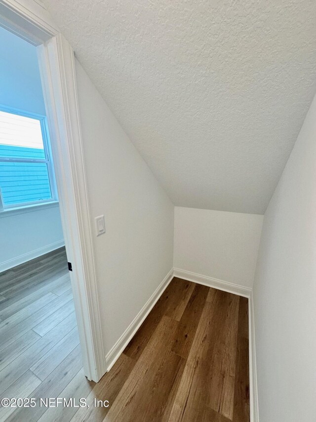 63 Oakmoss Dr, Saint Johns, FL 32259 - additional living space with a textured ceiling, baseboards, lofted ceiling, and dark wood-type flooring