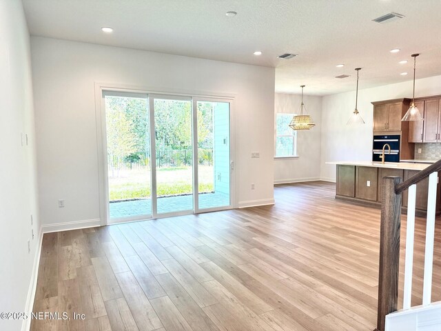 63 Oakmoss Dr, Saint Johns, FL 32259 - kitchen with light countertops, baseboards, light wood-style flooring, and visible vents
