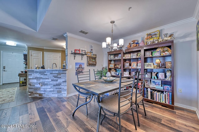 dining space with an inviting chandelier, hardwood / wood-style flooring, and ornamental molding