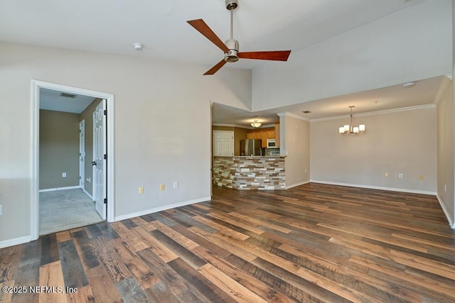 unfurnished living room with lofted ceiling, crown molding, dark hardwood / wood-style floors, and ceiling fan with notable chandelier