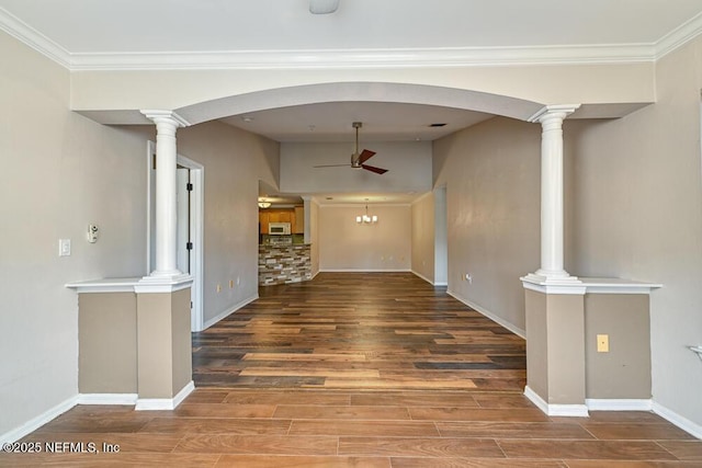 interior space featuring crown molding, decorative columns, and dark hardwood / wood-style floors