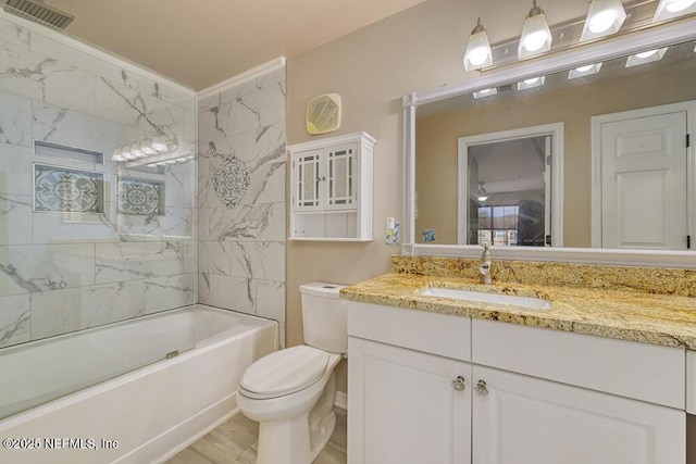 full bathroom with vanity, toilet, and tiled shower / bath