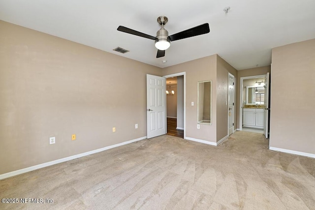 unfurnished bedroom featuring light carpet, ceiling fan, and connected bathroom