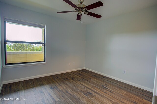 unfurnished room featuring dark wood-type flooring and ceiling fan