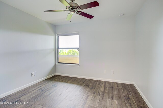 empty room featuring dark wood-type flooring and ceiling fan