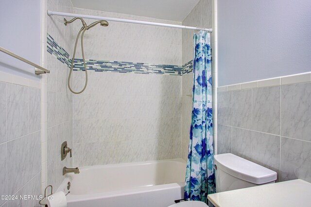 full bathroom featuring tile walls, toilet, shower / bathtub combination with curtain, and vanity