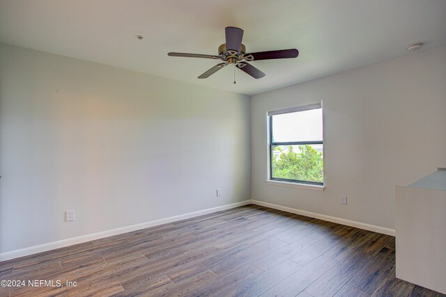 empty room with dark wood-type flooring and ceiling fan