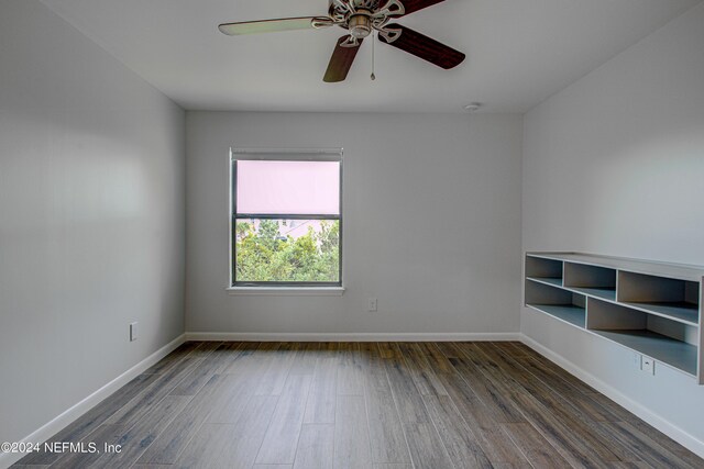 spare room with dark wood-type flooring and ceiling fan