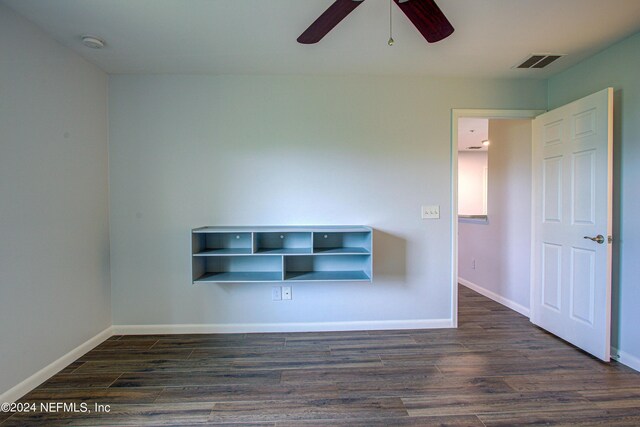 spare room with dark wood-type flooring and ceiling fan