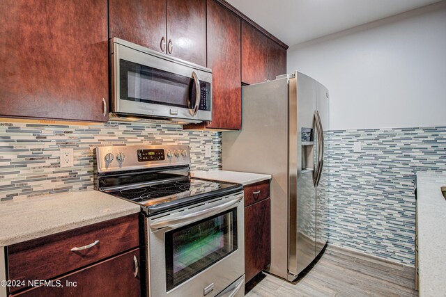 kitchen with appliances with stainless steel finishes and backsplash