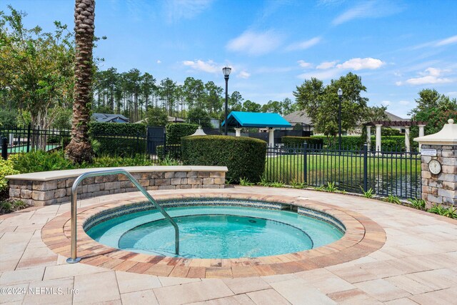 view of swimming pool with a hot tub