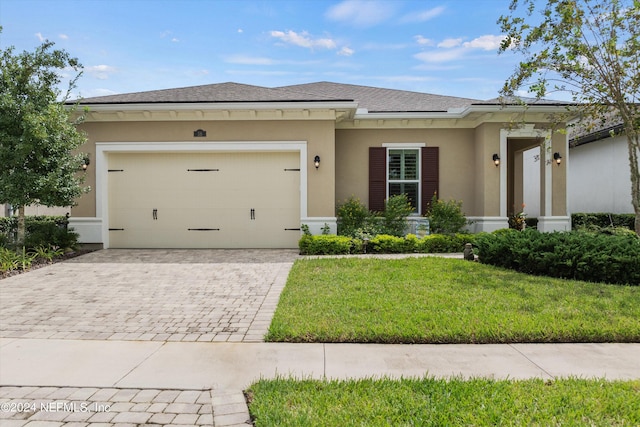 view of front of property featuring a garage and a front lawn