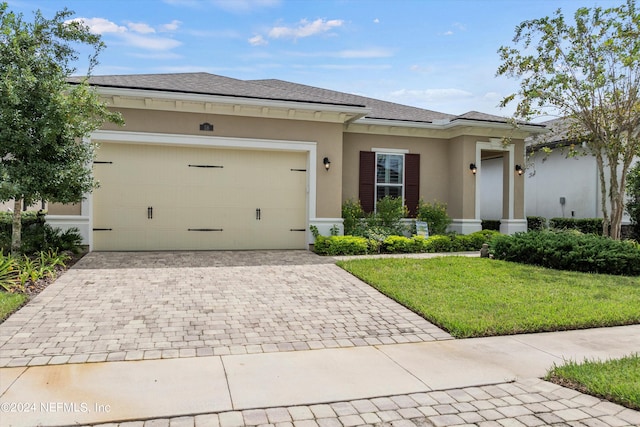 prairie-style home with a front yard and a garage