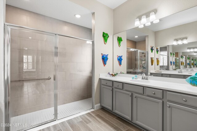 bathroom with vanity and a shower with door