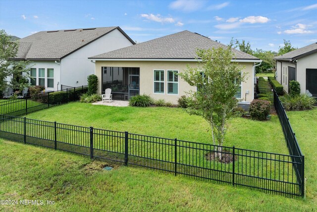 rear view of house featuring a lawn