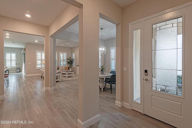 foyer entrance with a chandelier and light hardwood / wood-style flooring