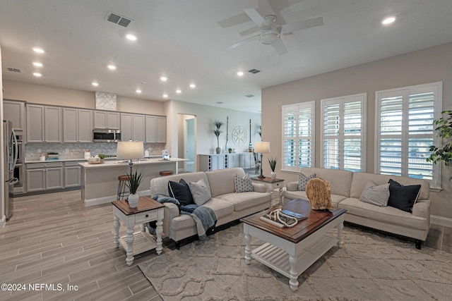 living room featuring ceiling fan and light hardwood / wood-style flooring