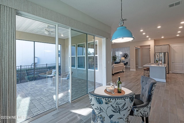 dining space with light hardwood / wood-style floors and ceiling fan