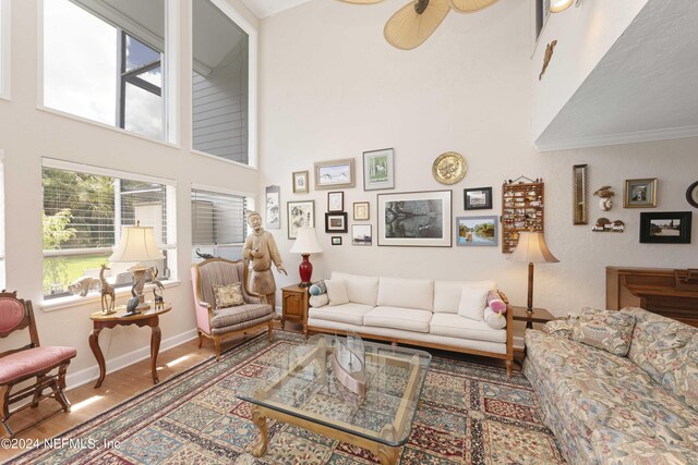 living room with ornamental molding, hardwood / wood-style floors, and ceiling fan