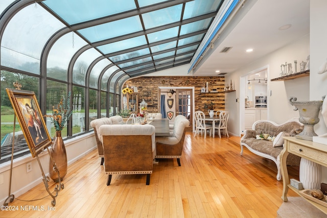 sunroom / solarium featuring vaulted ceiling