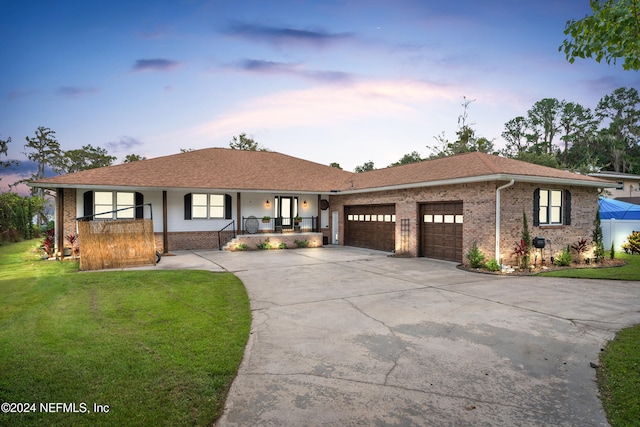 view of front of house featuring a garage, a yard, and a porch