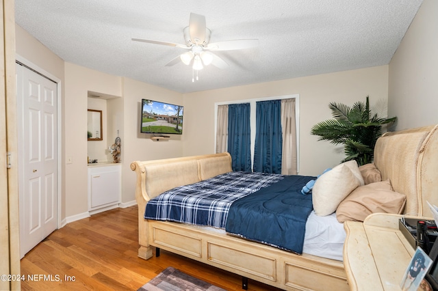 bedroom featuring wood-type flooring, a textured ceiling, and ceiling fan