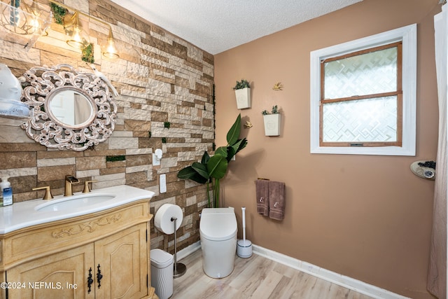 bathroom featuring vanity, toilet, a textured ceiling, and wood-type flooring