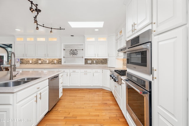 kitchen with sink, white cabinets, stainless steel appliances, and tasteful backsplash